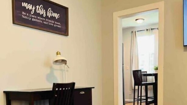 A dining area with a table and chairs, a decorative elephant sculpture, and a wall sign.