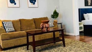 A living room with a sofa, coffee table, and patterned rug.