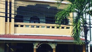 A two-story building with a central entrance, a balcony on the upper floor, and a stone facade. - Caribbean Hotel Santo Domingo (Santo Domingo)