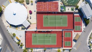 An aerial view of a sports complex with multiple tennis courts, a basketball court, and a covered area with solar panels. - Cozy Venture Out Cottage (Cudjoe Key)