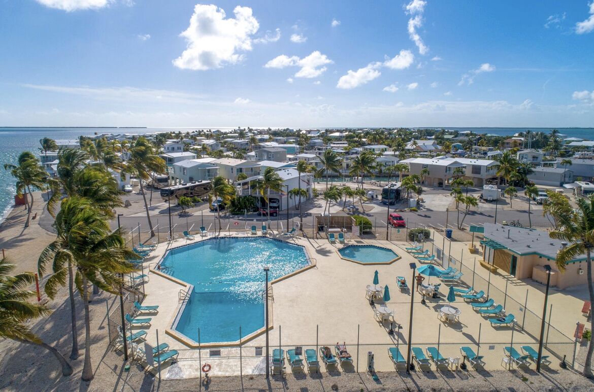 A resort with multiple swimming pools, palm trees, and beach views.