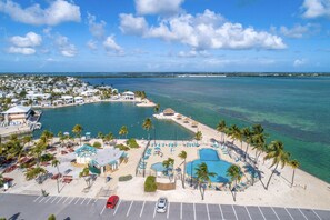 Un complexe hôtelier doté d’une piscine, d’une plage et offrant une vue sur l’océan.