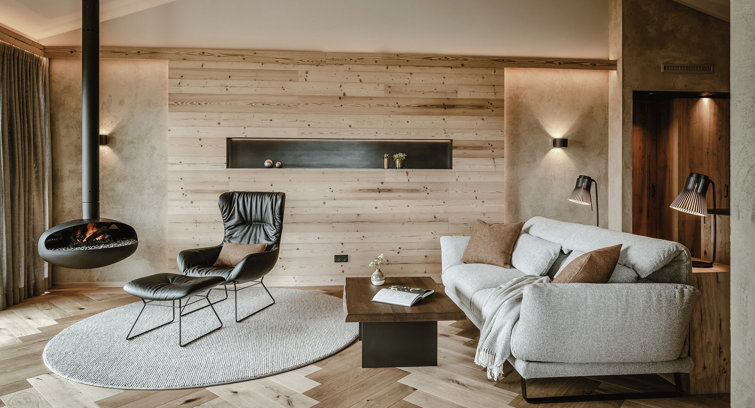 Una sala moderna con chimenea, un sofá, un sillón y una mesa de centro.