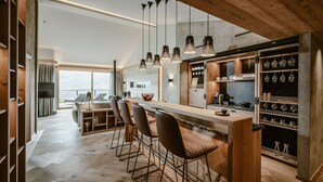Une cuisine moderne dotée d’un îlot central, de tabourets de bar, de luminaires suspendus et offrant une vue sur la ville.