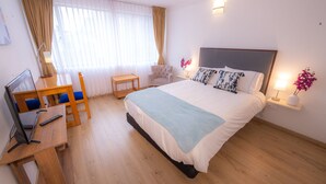 A hotel room with a bed, desk, chair, and a TV. - ★Best Location in Bogotá. Private Studio+WIFI ★ (Bogotá)