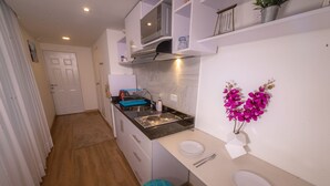 A compact kitchen with a microwave, sink, and a small dining area with a white plate and utensils. - ★Best Location in Bogotá. Private Studio+WIFI ★ (Bogotá)