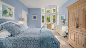 Ein Schlafzimmer mit Bett, Schreibtisch und Kleiderschrank.