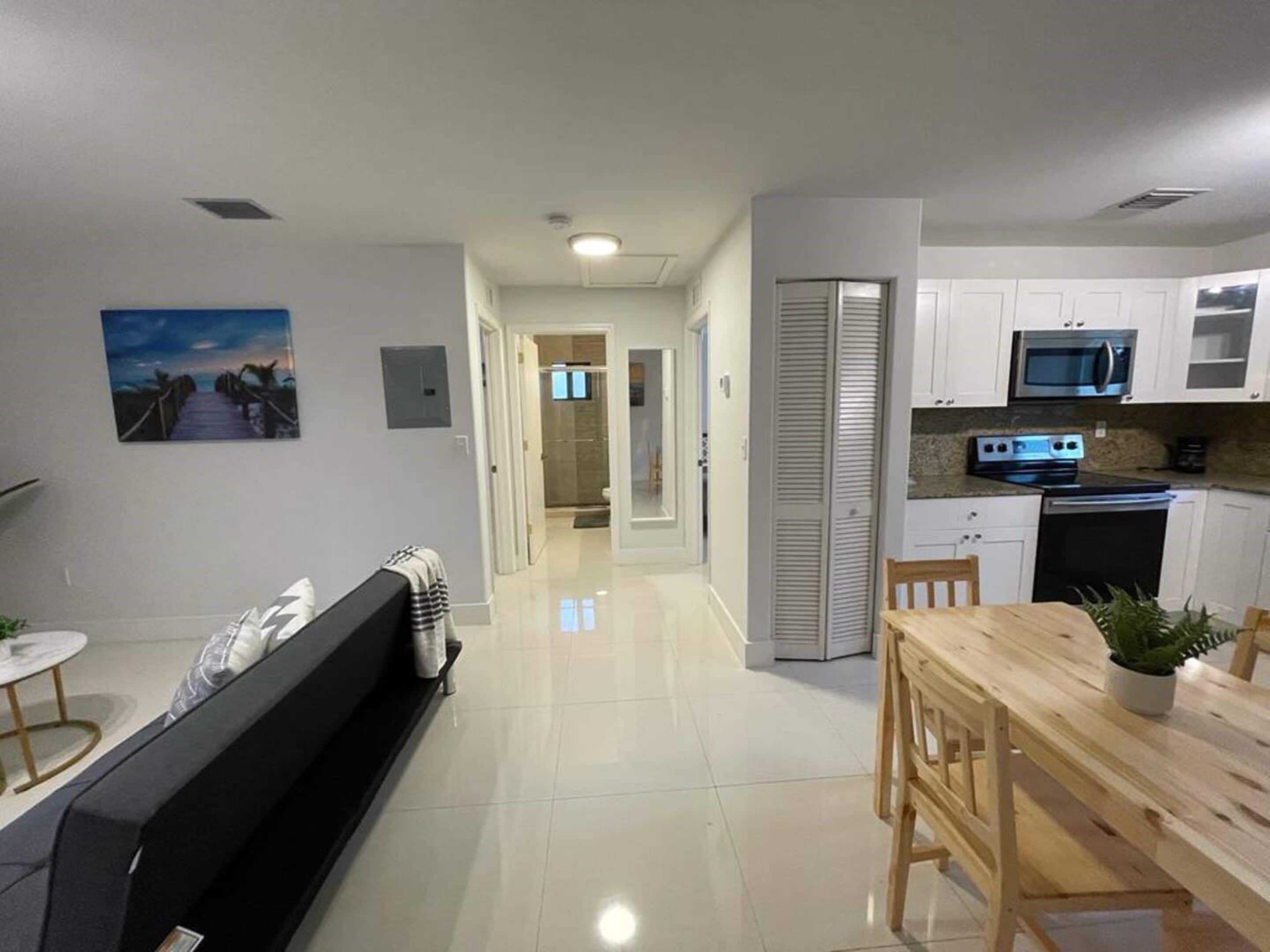 A modern apartment with a living room, dining area, and kitchen.