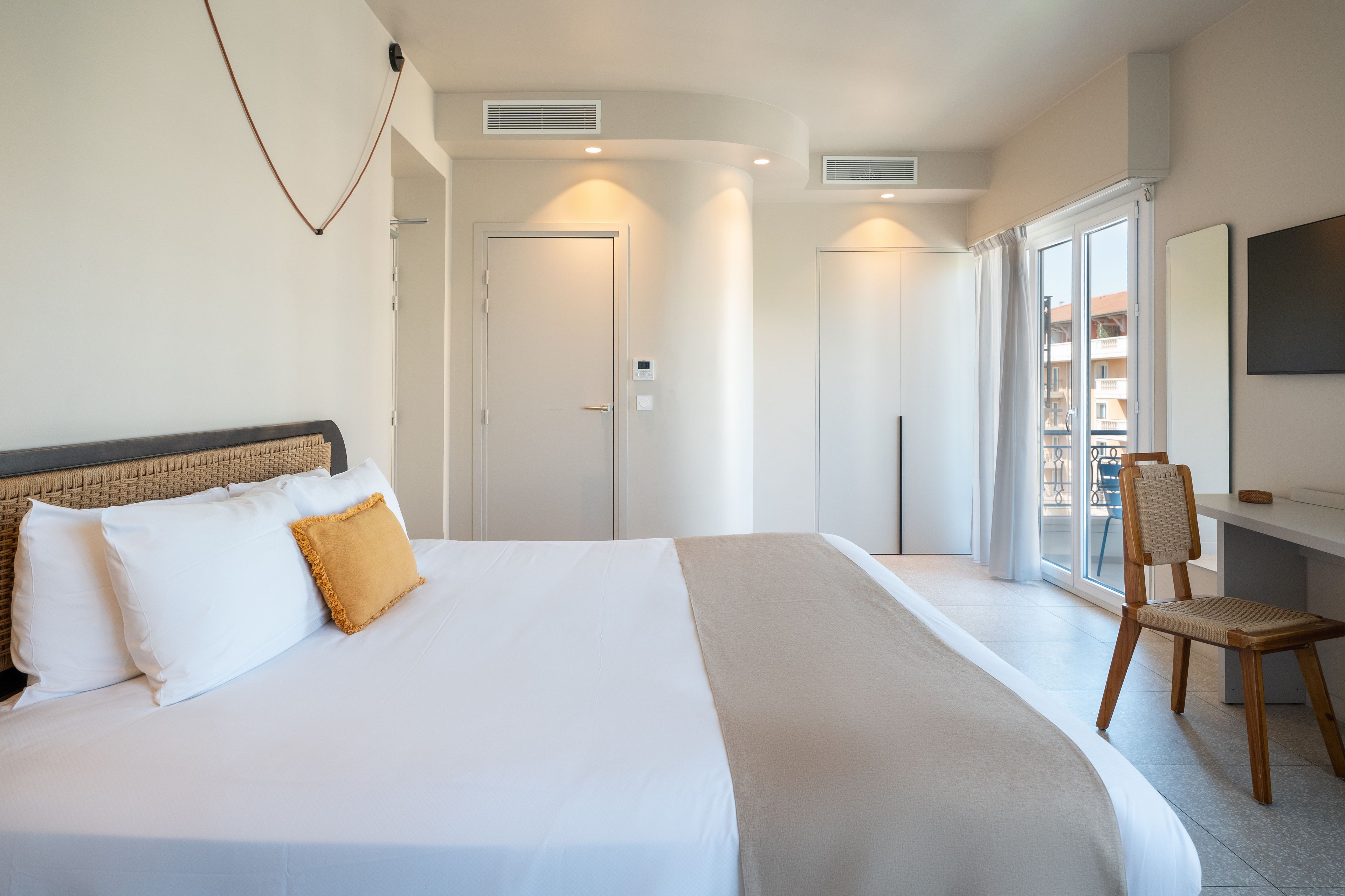 Une chambre d’hôtel avec un grand lit, une chaise, un bureau et une télévision.