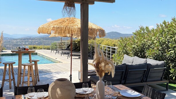 A dining area with a pool, outdoor seating, and a view of the mountains. - Splendid villa with swimming pool & sea view (Roquebrune-sur-Argens)
