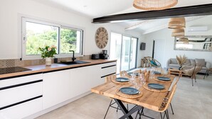 A modern kitchen with a wooden island, white cabinets, and a large window. - Splendid villa with swimming pool & sea view (Roquebrune-sur-Argens)