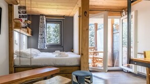 A cozy cabin-style room with a bed, a wooden bench, and a table.