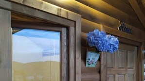 A wooden log cabin with a large window and a door. - Blue bungalow Bosnian pyramid glamping (Visoko)