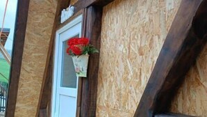 A room with exposed wooden beams and a window with a white frame. - Red bungalow Bosnian pyramid glamping (Visoko)