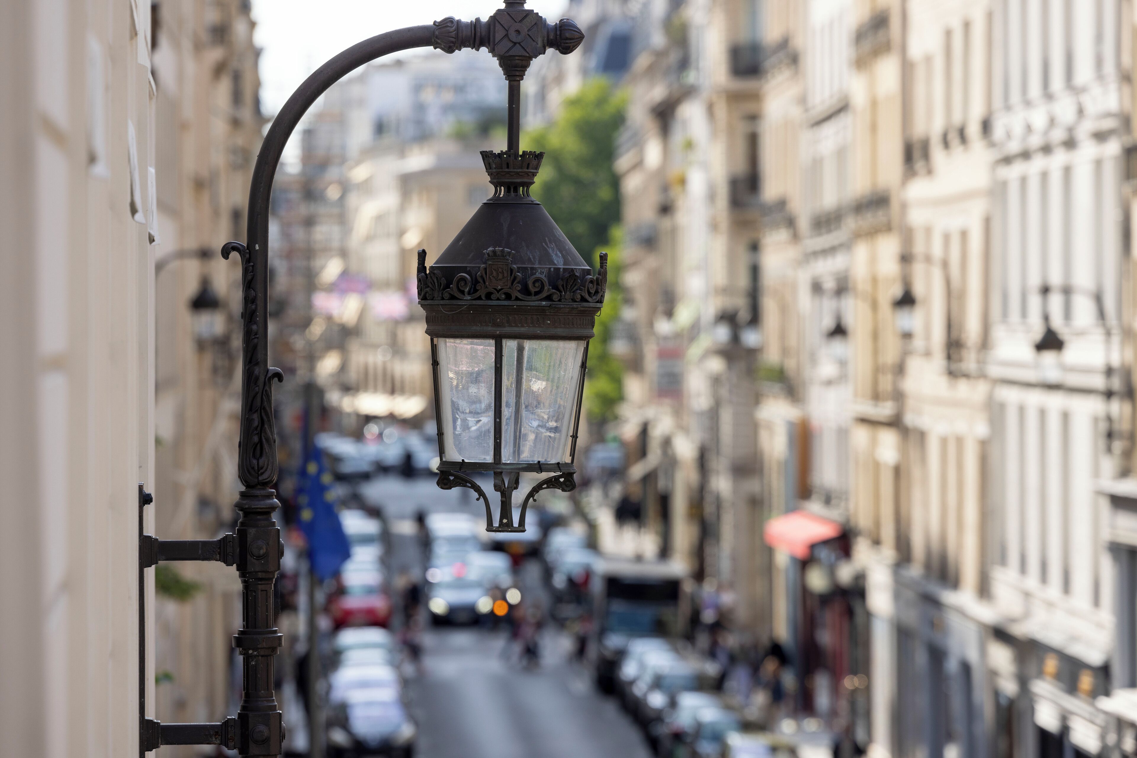 Vista de una calle con un farol antiguo y edificios a ambos lados.