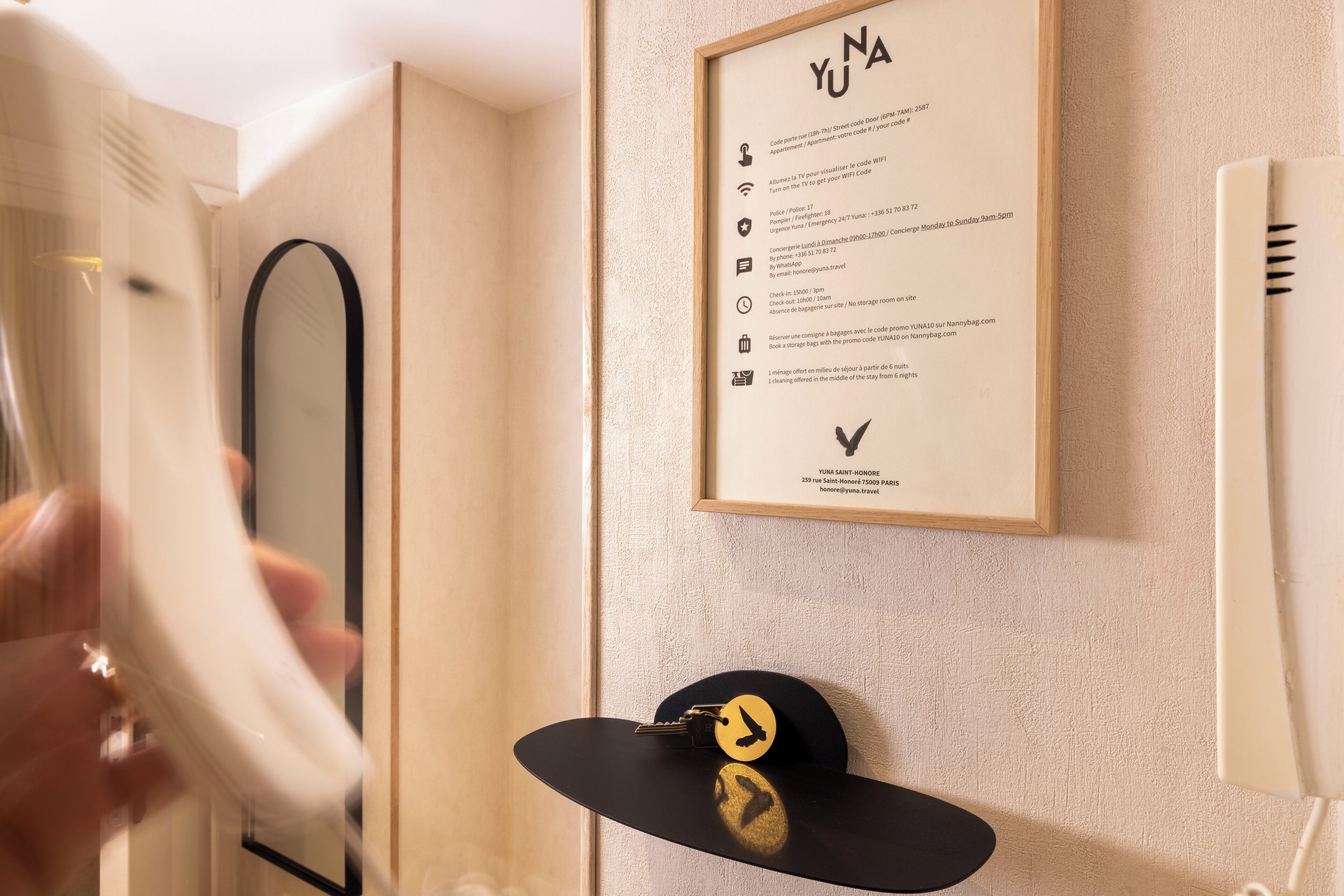 A framed sign with text and a black hat with a gold emblem on a wall.