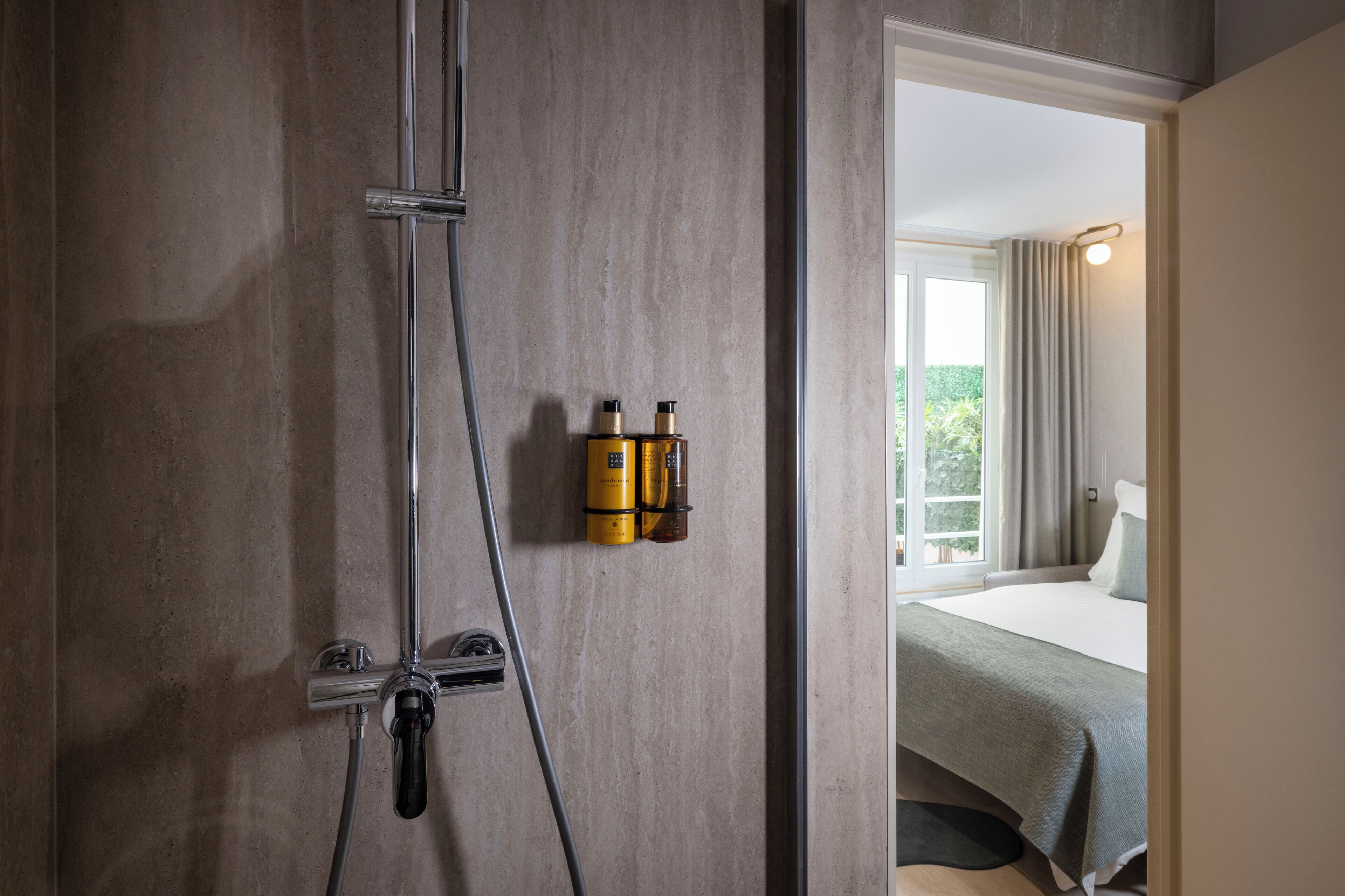 Een moderne badkamer met een douche, een handdoekhouder en een zichtbaar raam.