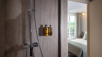 Een moderne badkamer met een douche, een handdoekhouder en een zichtbaar raam.