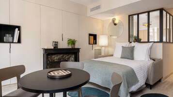 Una habitación de hotel moderna con una cama, una mesa redonda y una chimenea.