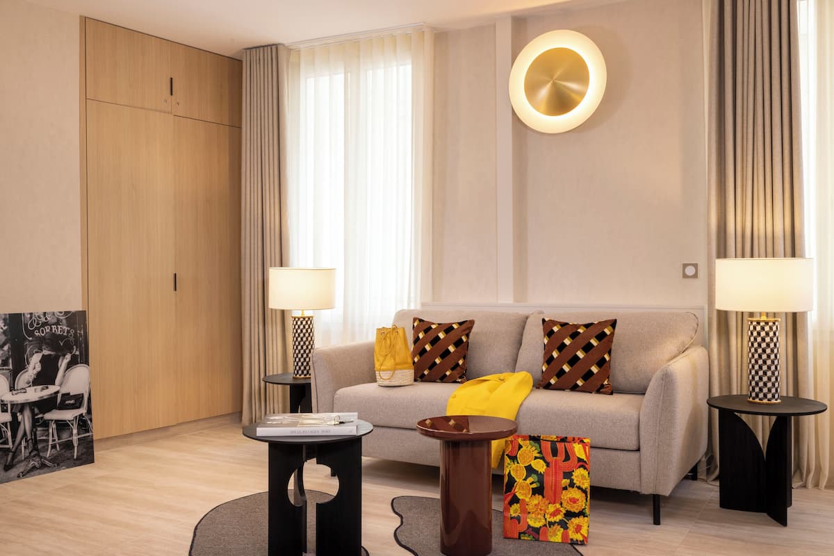 A modern living room with a sofa, two side tables, a coffee table, and a decorative pillow.