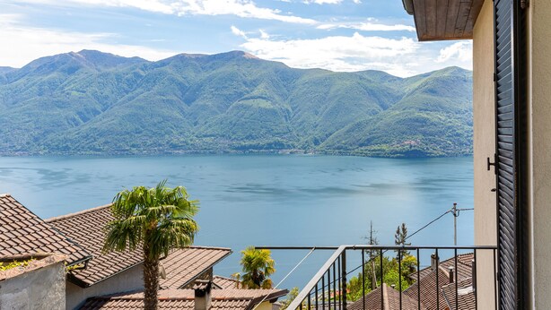 Un balcon avec vue sur un lac et des montagnes.