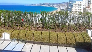 Vista de una ciudad costera con cielo azul despejado, una playa y edificios modernos.