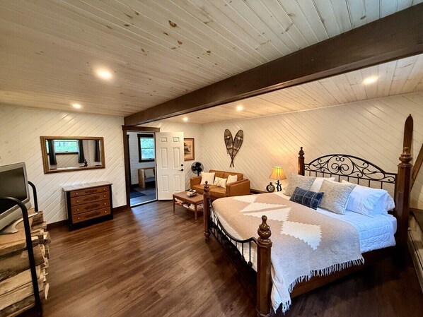 A bedroom with a wooden bed, a dresser, a desk, and a chair.