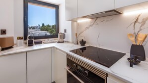 Eine moderne Küche mit großem Fenster, eingebautem Herd und Marmor-Spritzschutz.
