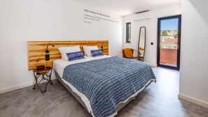 Ein Schlafzimmer mit Bett, Nachttisch und einem an der Wand befestigten Spiegel.
