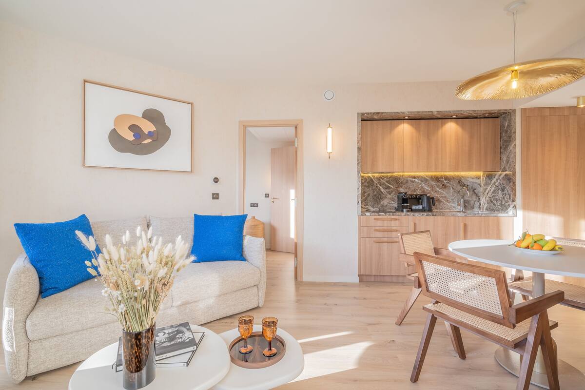 Ein modernes Wohnzimmer mit Sofa, Couchtisch und Essbereich.