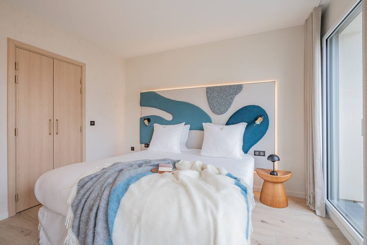 Ein modernes Schlafzimmer mit einem großen Bett, einem Holzschrank und einem außergewöhnlichen Wandbild.