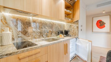 Eine moderne Küche mit Marmorarbeitsplatten, Holzschränken und einem eingebauten Geschirrspüler.