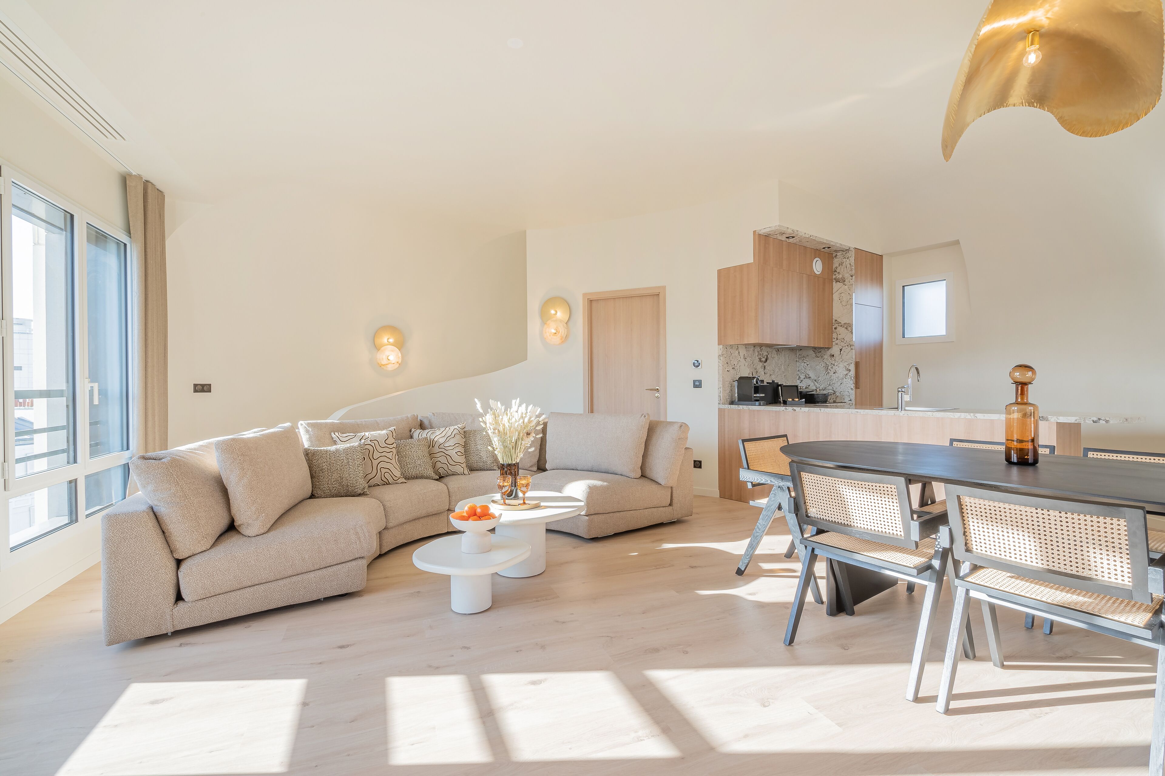 A modern living room with a sofa, coffee table, and dining table with chairs.