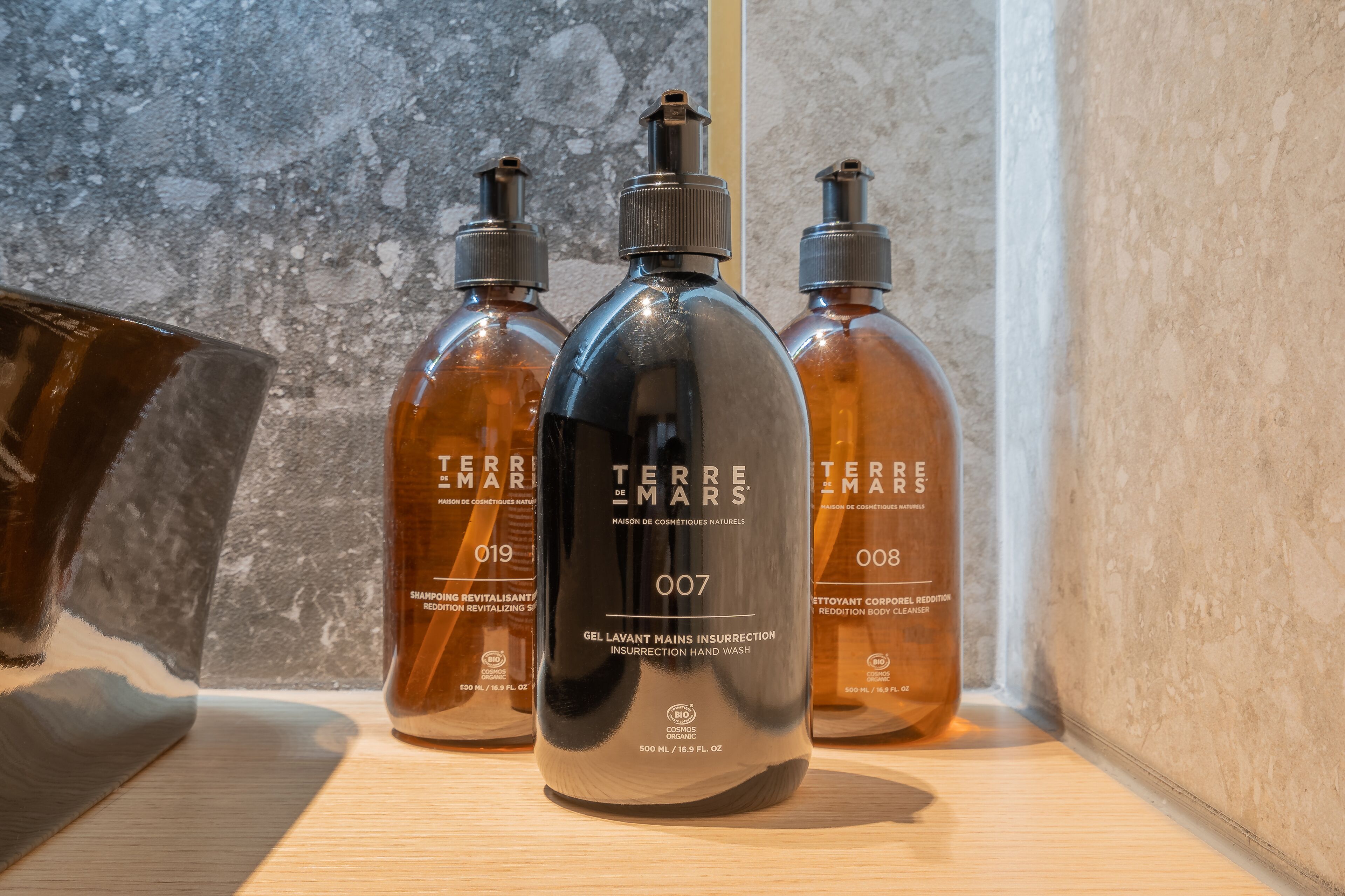 Three bottles of Terre de Mars hand wash on a wooden shelf.
