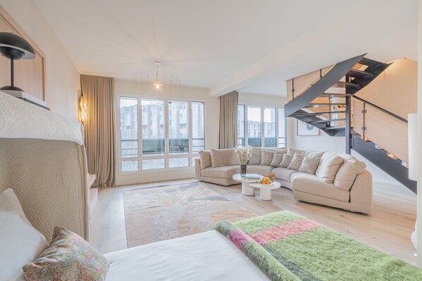 Una sala de estar moderna con un sofá, una mesa de centro y una escalera.