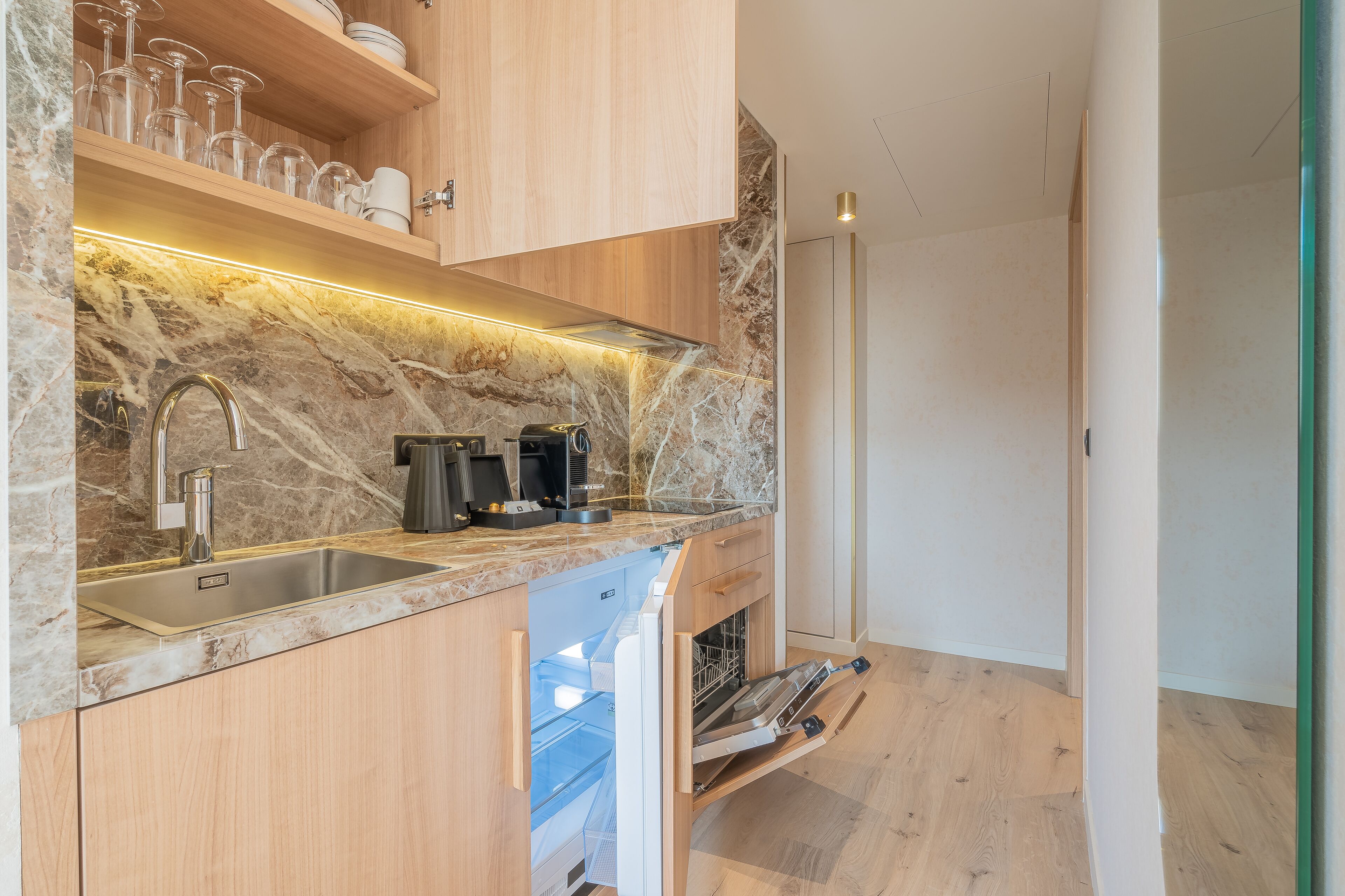 A modern kitchen with a marble backsplash, wooden cabinets, and built-in appliances.