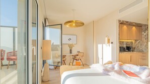 A modern hotel room with a large bed, a dining area, and a kitchen. - Yuna Porte Maillot - ApartHotel (Paris)
