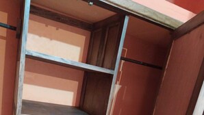 Ein schmaler, hölzerner Schrank mit Metallregalen.