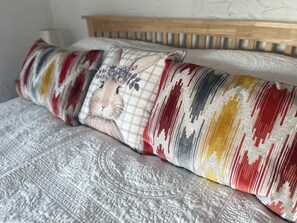 A bed with a patterned quilt and a pillow with a lion design. - The Coach House (Holywell)