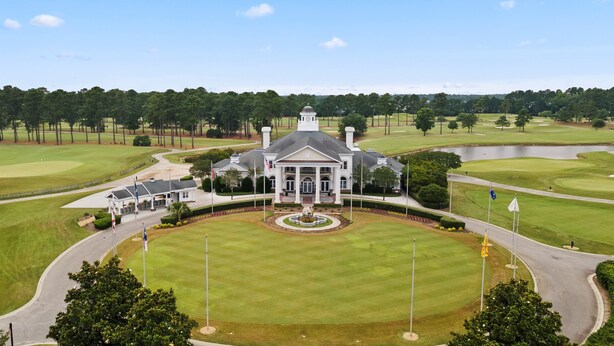 A large, white building with a central dome and a formal entrance, surrounded by well-maintained lawns and a golf course. - World Tour Golf Course overlooking the greens. Spacious 2 Bed 2 Bath on the 9th. (Myrtle Beach)