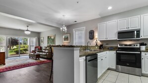 A modern kitchen with white cabinets, a stainless steel dishwasher, and a built-in microwave. - World Tour Golf Course overlooking the greens. Spacious 2 Bed 2 Bath on the 9th. (Myrtle Beach)