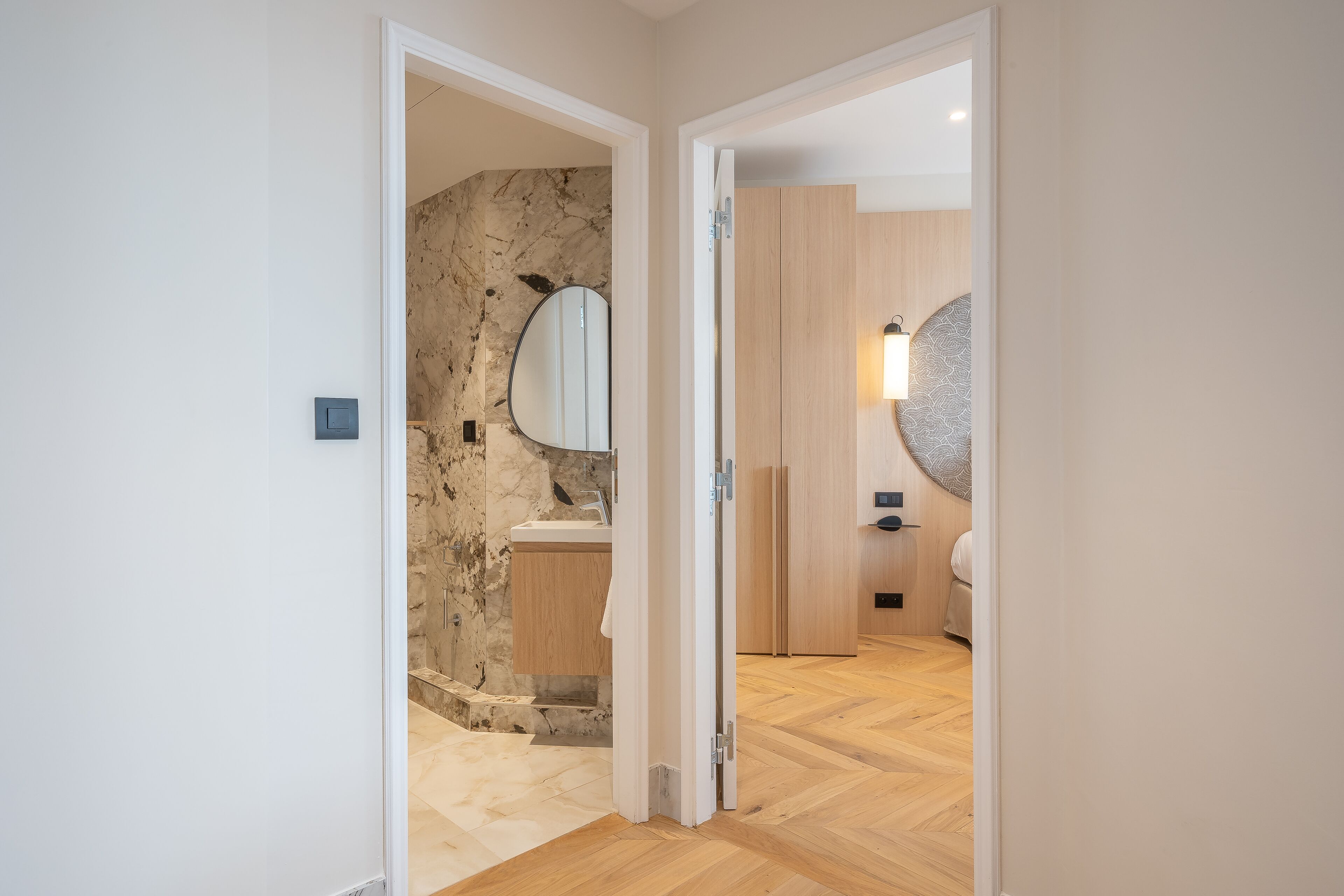 Ein modernes Badezimmer mit Marmorwand, Waschbecken und Toilette.