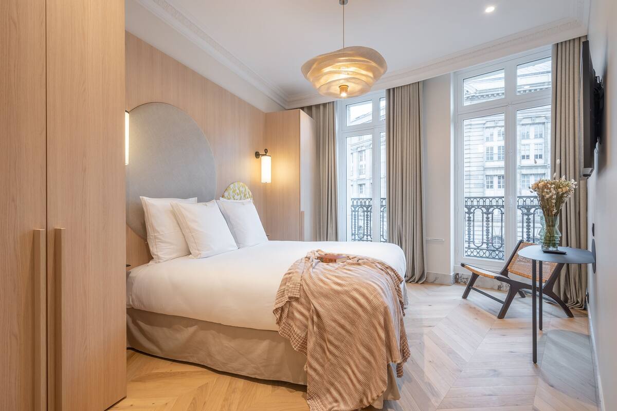 Ein Hotelzimmer mit einem großen Bett, einem kleinen Tisch und einem Stuhl.