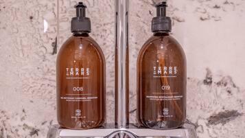 Dos botellas de limpiador corporal y champú revitalizante Terre de Mars sobre una encimera de baño.