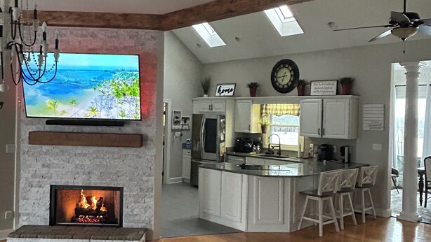 Ein geräumiges Wohnzimmer mit Kamin, Fernseher und einer gemütlichen Sitzecke.