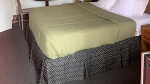 Une pièce comprenant un lit, une petite table, une chaise, une lampe et un mur décoré d’assiettes.