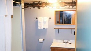 A bathroom with a toilet, sink, and shower.