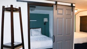 A room with a bed, a desk, and a wardrobe.