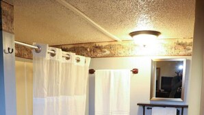 Une salle de bain avec une baignoire, un lavabo et un miroir.