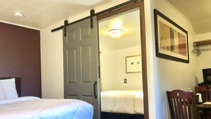 Une chambre d’hôtel avec un lit, un bureau et une chaise.